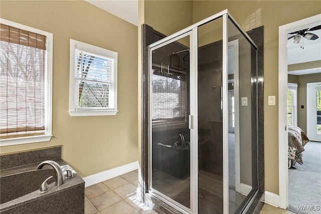 bathroom with ceiling fan, a shower with shower door, and tile patterned flooring