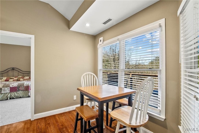 dining room featuring hardwood / wood-style floors and vaulted ceiling