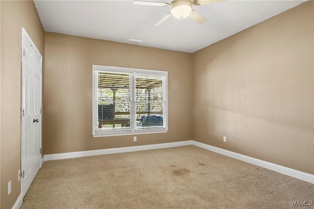 carpeted spare room featuring ceiling fan