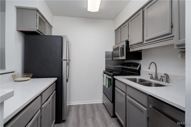 1009 12th St Unit 22, Tuscaloosa, AL 35401 - kitchen with stainless steel appliances, gray cabinetry, light wood finished floors, and light stone countertops