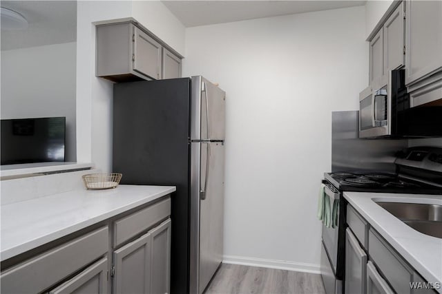 1009 12th St Unit 22, Tuscaloosa, AL 35401 - kitchen featuring gray cabinets, stainless steel appliances, light countertops, and light wood-style floors