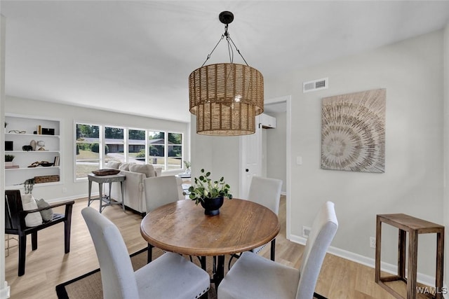 dining space featuring built in shelves and light wood-type flooring