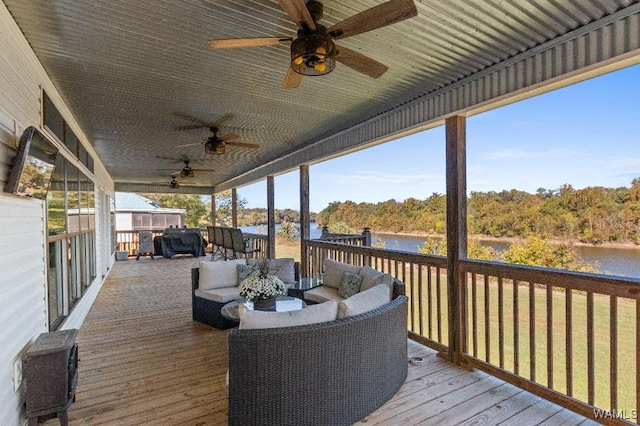 wooden terrace with a water view, ceiling fan, grilling area, and an outdoor living space