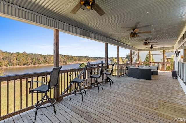 wooden deck featuring a water view, ceiling fan, and an outdoor living space