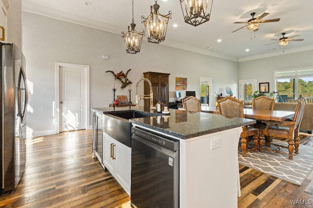 kitchen with sink, white cabinetry, dishwasher, a kitchen island, and stainless steel refrigerator