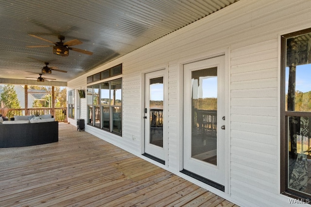 wooden deck with an outdoor hangout area and ceiling fan