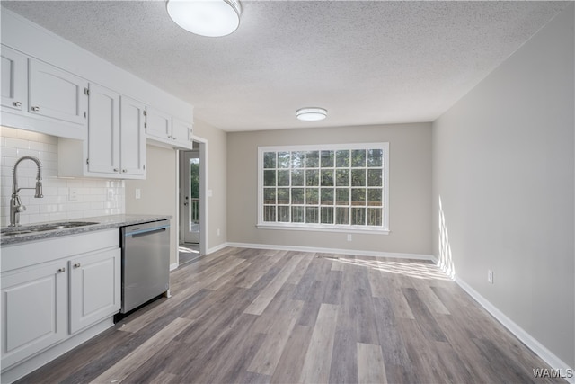 kitchen with sink, dishwasher, light stone countertops, decorative backsplash, and white cabinets