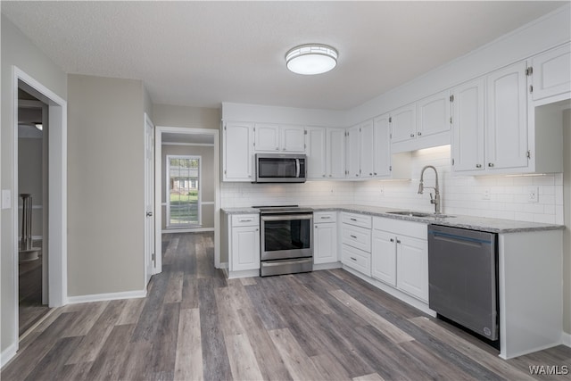 kitchen featuring white cabinetry, stainless steel appliances, dark wood-type flooring, and sink