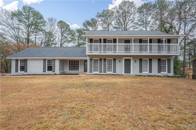 view of front of house featuring a balcony and a front yard