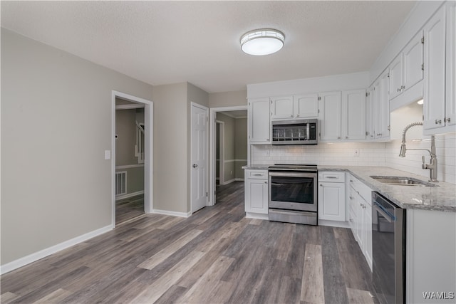 kitchen featuring tasteful backsplash, stainless steel appliances, sink, and white cabinets