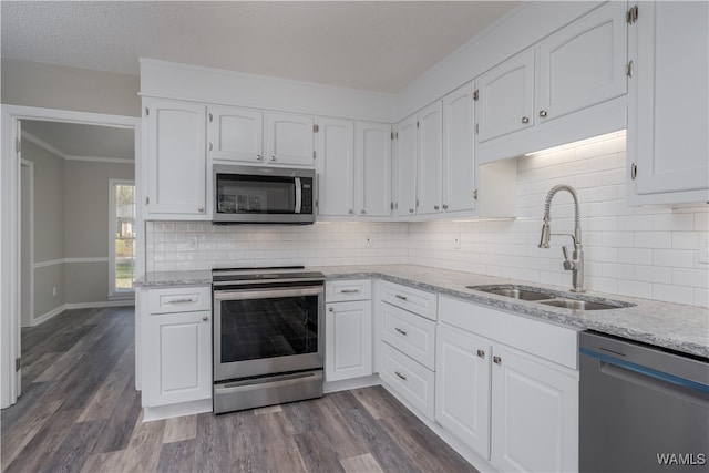 kitchen featuring sink, white cabinets, dark hardwood / wood-style flooring, stainless steel appliances, and light stone countertops