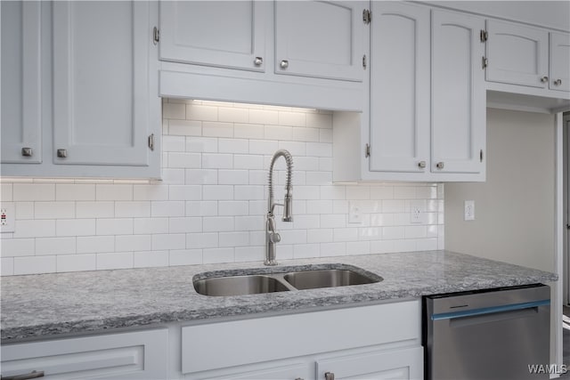 kitchen with white cabinetry, sink, backsplash, and stainless steel dishwasher