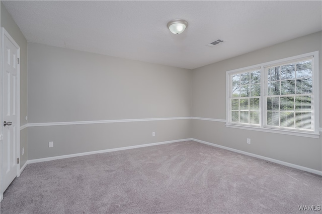 unfurnished room featuring carpet flooring and a textured ceiling