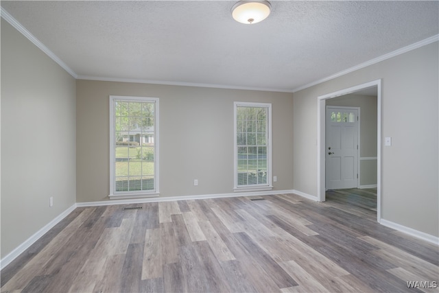 unfurnished room featuring ornamental molding, a textured ceiling, and light wood-type flooring