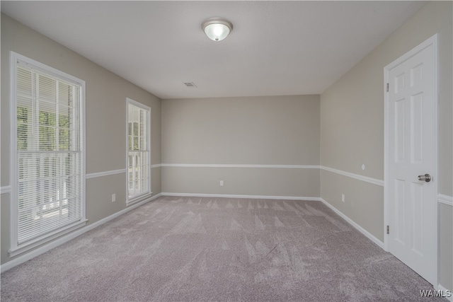 unfurnished room featuring light colored carpet