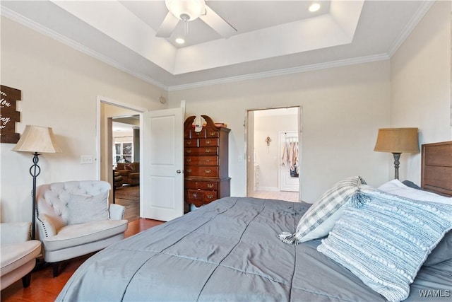 bedroom featuring wood finished floors, ceiling fan, crown molding, connected bathroom, and a raised ceiling