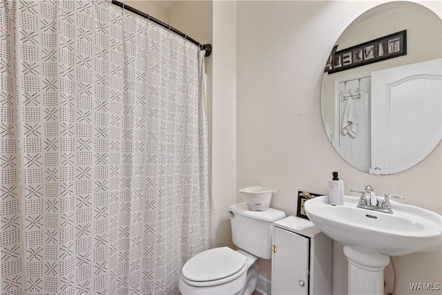 full bath with toilet and a shower with curtain