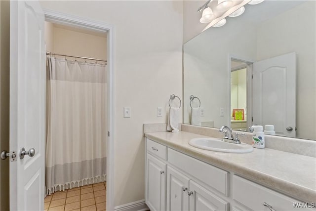 full bath featuring baseboards, vanity, and tile patterned floors
