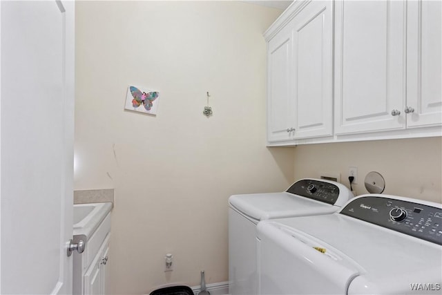 clothes washing area featuring washer and dryer and cabinet space