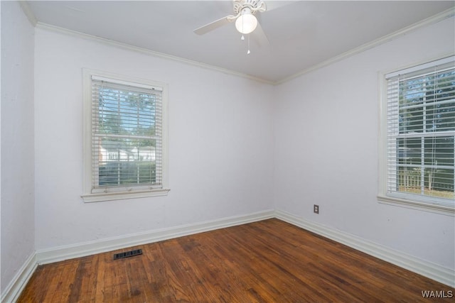 empty room with a wealth of natural light, ornamental molding, and wood-type flooring