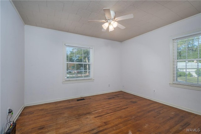 spare room featuring crown molding, dark wood-type flooring, and ceiling fan