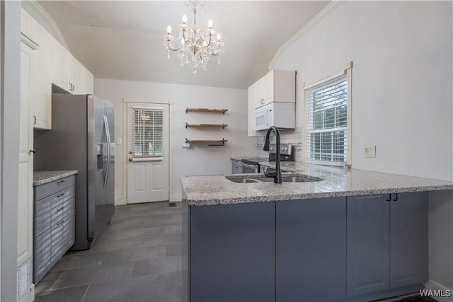 kitchen with sink, decorative light fixtures, kitchen peninsula, stainless steel appliances, and white cabinets