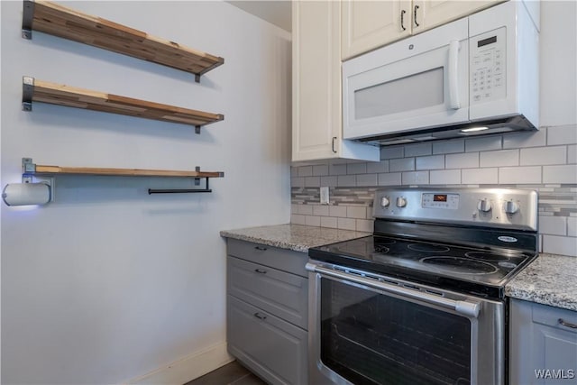 kitchen with white cabinetry, backsplash, light stone counters, and electric range