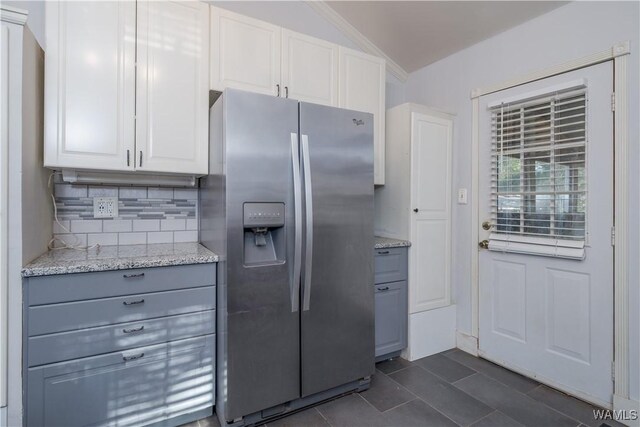 kitchen with white cabinetry, light stone counters, stainless steel fridge, and gray cabinetry