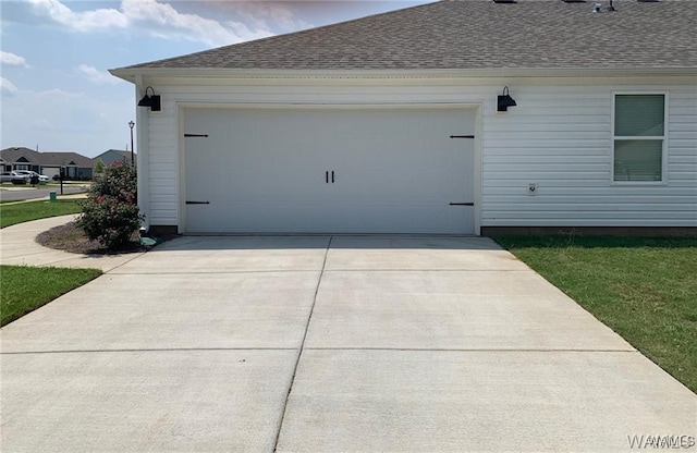 7106 Dowery Dell Way, Northport, AL 35473 - view of side of property with an attached garage, a shingled roof, and concrete driveway
