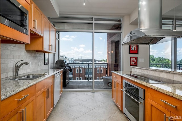 1018 Hackberry Ln Unit 404, Tuscaloosa, AL 35401 - kitchen featuring island range hood, expansive windows, appliances with stainless steel finishes, tasteful backsplash, and light stone countertops