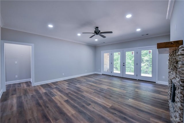 unfurnished living room featuring french doors, ceiling fan, crown molding, dark wood-type flooring, and a fireplace