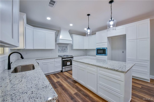 kitchen with white cabinetry, sink, light stone countertops, custom range hood, and appliances with stainless steel finishes