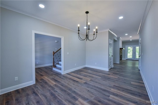 unfurnished dining area featuring a notable chandelier, dark hardwood / wood-style flooring, crown molding, and french doors