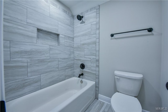 bathroom featuring hardwood / wood-style flooring, toilet, and tiled shower / bath