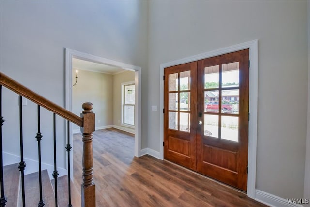 foyer entrance with french doors, hardwood / wood-style flooring, a wealth of natural light, and a high ceiling