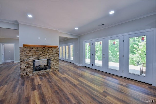 unfurnished living room featuring a stone fireplace, crown molding, plenty of natural light, and dark hardwood / wood-style floors