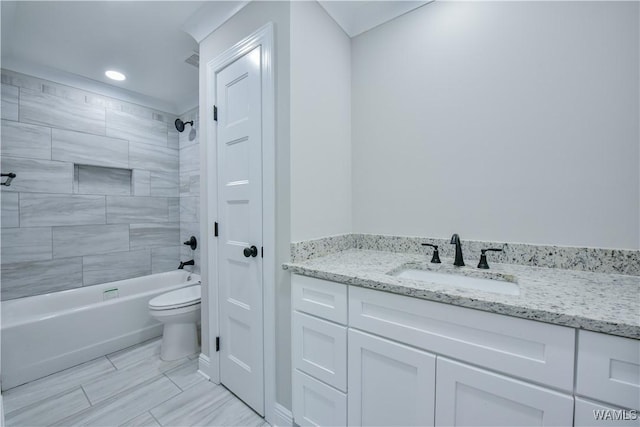full bathroom featuring tiled shower / bath, vanity, and toilet