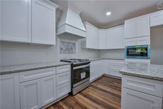 kitchen with dark hardwood / wood-style flooring, white cabinetry, premium range hood, and appliances with stainless steel finishes