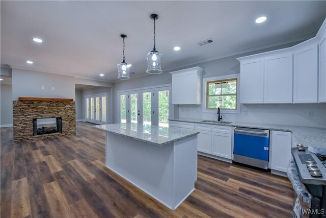 kitchen with a fireplace, dark hardwood / wood-style flooring, white cabinetry, and stainless steel appliances