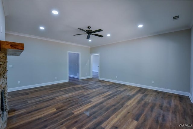unfurnished living room featuring dark hardwood / wood-style flooring, a stone fireplace, ceiling fan, and ornamental molding