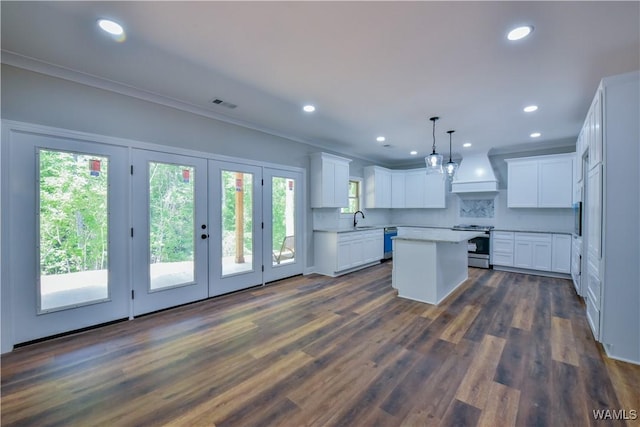 kitchen featuring white cabinetry, a kitchen island, a wealth of natural light, and sink
