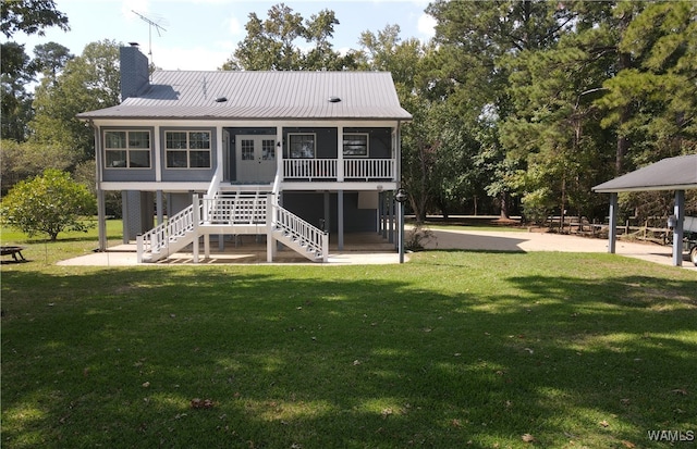 rear view of house with a sunroom and a yard