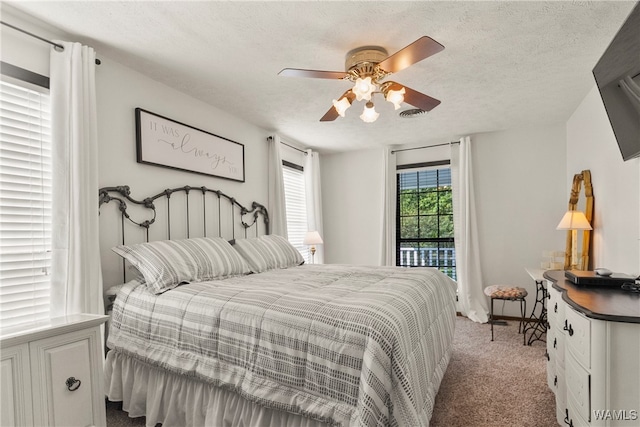 bedroom featuring ceiling fan, light colored carpet, and a textured ceiling