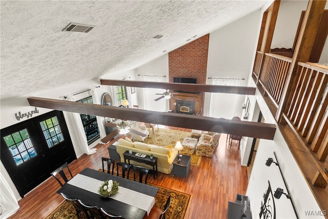 living room featuring a textured ceiling, hardwood / wood-style flooring, a wealth of natural light, and ceiling fan