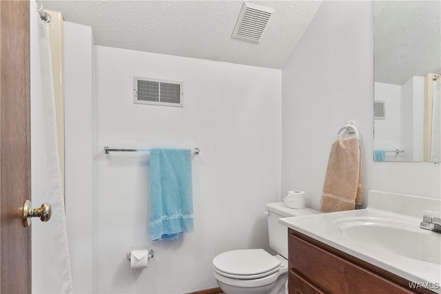 bathroom with vanity, a textured ceiling, and toilet