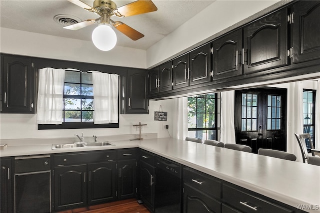 kitchen featuring kitchen peninsula, ceiling fan, dark wood-type flooring, sink, and dishwasher