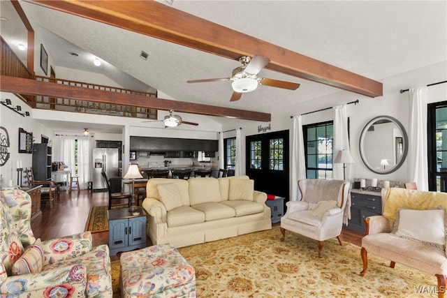 living room featuring plenty of natural light, lofted ceiling with beams, and wood-type flooring