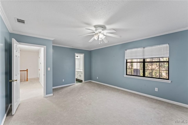 unfurnished bedroom featuring connected bathroom, ornamental molding, light colored carpet, and ceiling fan