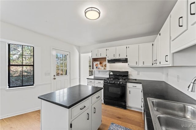 kitchen with light wood-type flooring, black range with gas cooktop, sink, and white cabinets