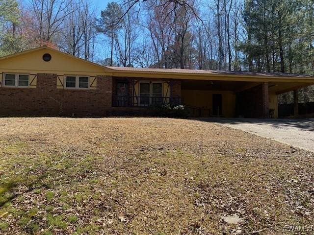 ranch-style home with an attached carport, concrete driveway, and brick siding